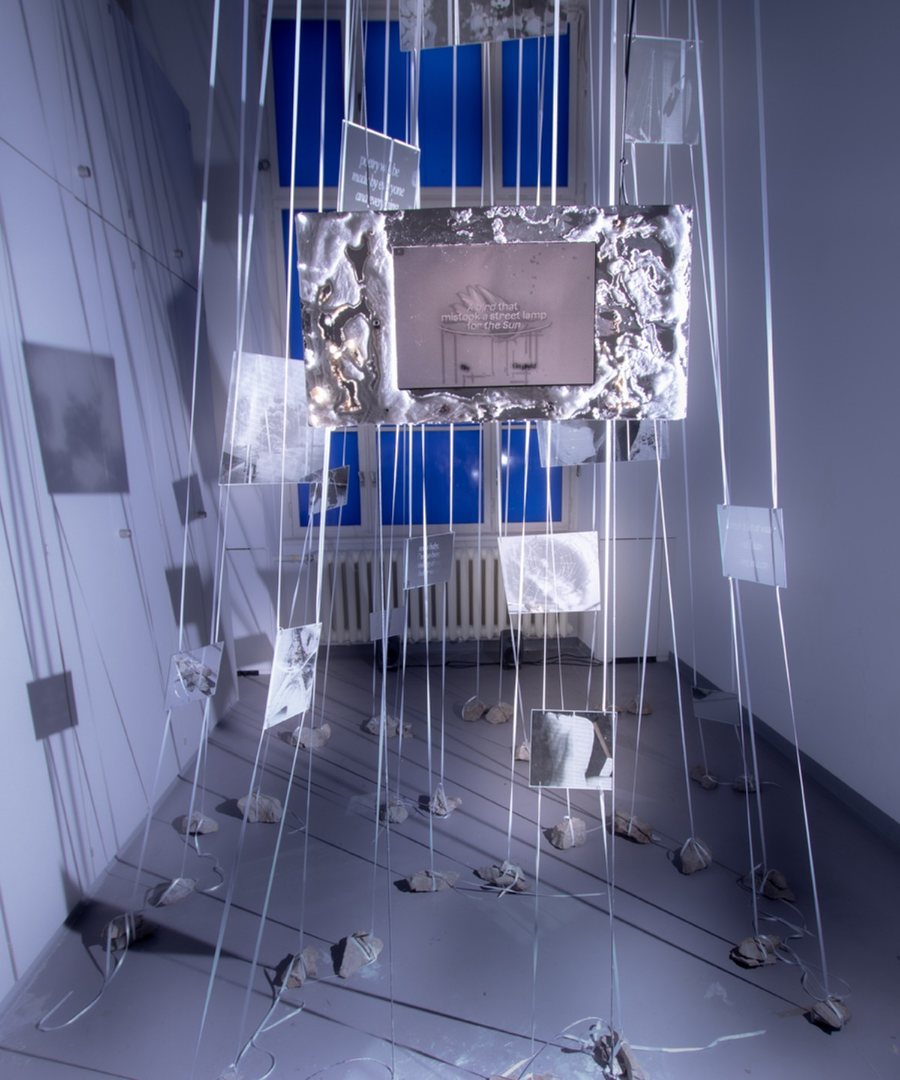 Installation view with a screen suspended in a metallic frame.