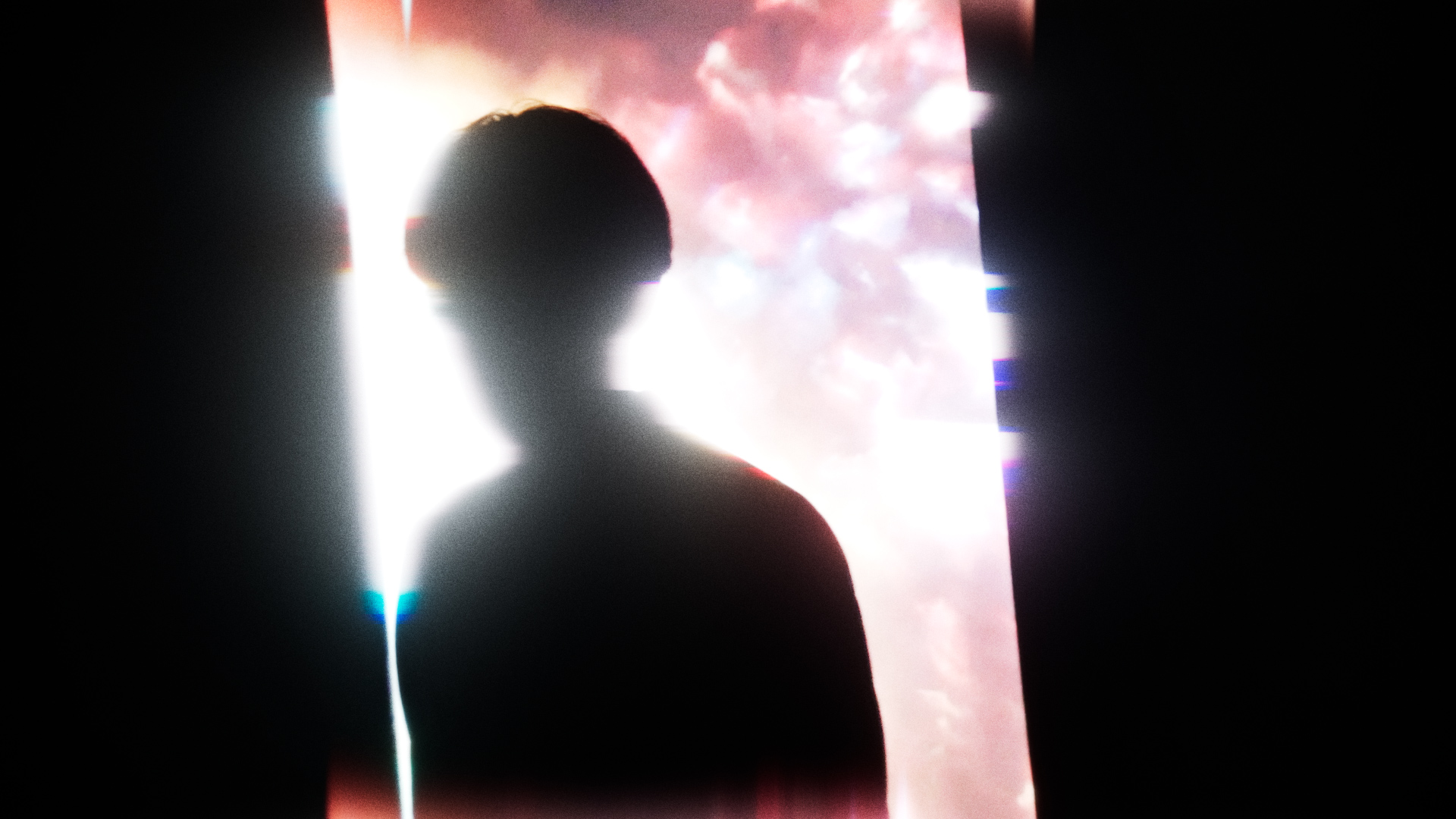Performer silhouette in front of a bright projection.